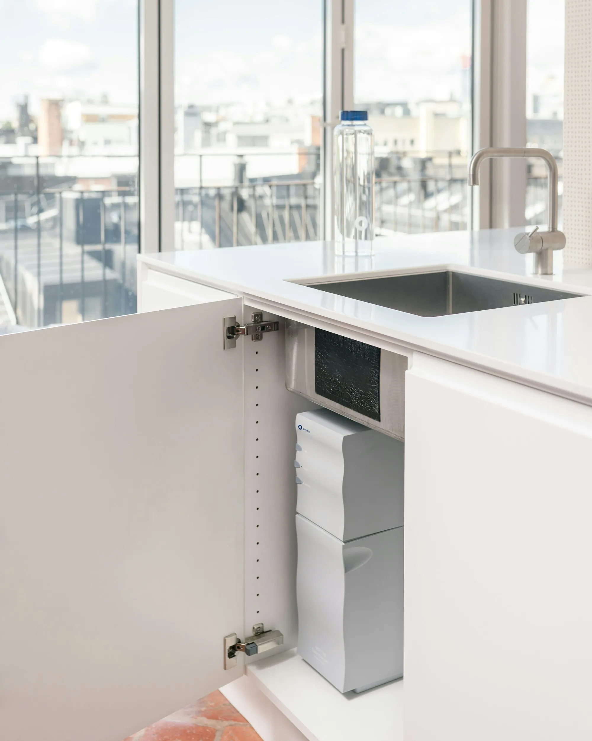 Under-Sink Drinking Water Filters in Lake Forest, CA Open cabinet under a kitchen sink with a compact water filter unit inside