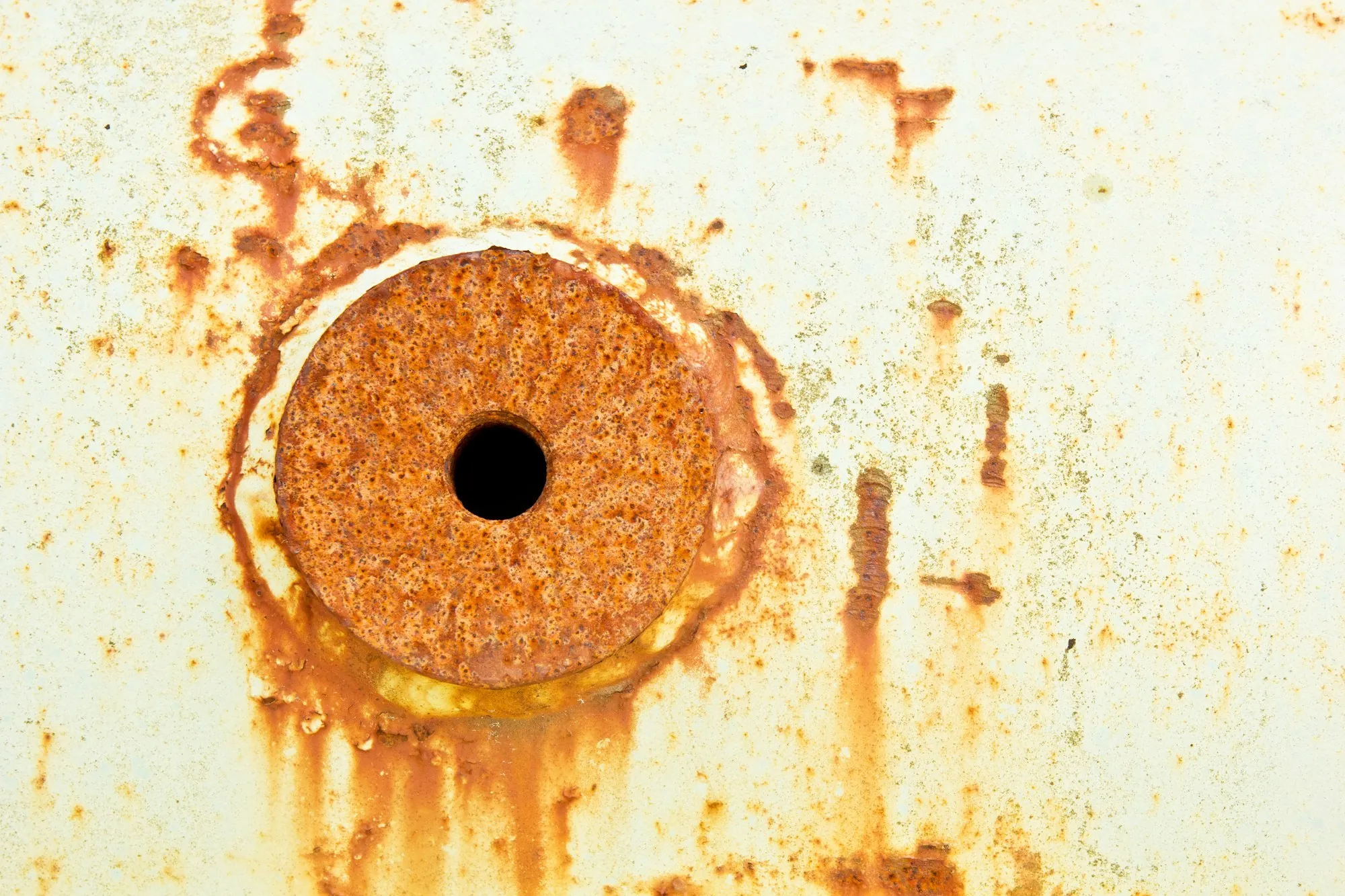 Iron & Sulfur Removal in Lake Forest, CA Orange rust stains around a hole in a white metal surface