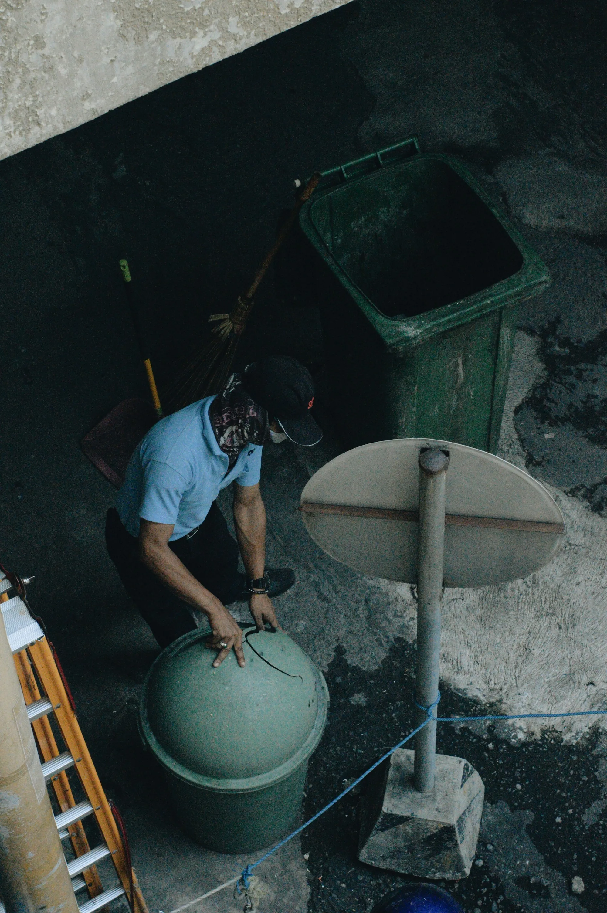 Water Filter Repair & Maintenance in Lake Forest, CA Technician in a helmet servicing a green water tank below ground